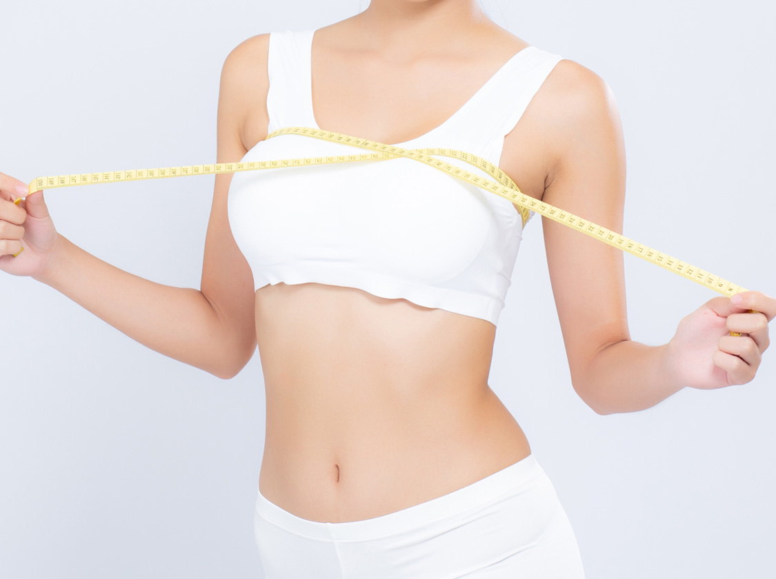 Beautiful portrait asian woman diet and slim with measuring breast and augmentation isolated on white background