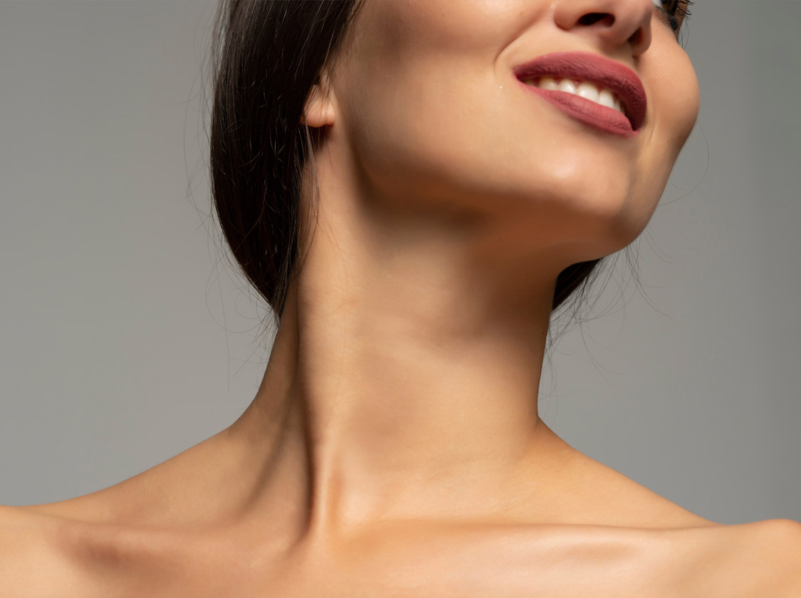 Smiling woman with her chin raised, showing a smooth neck and shoulders